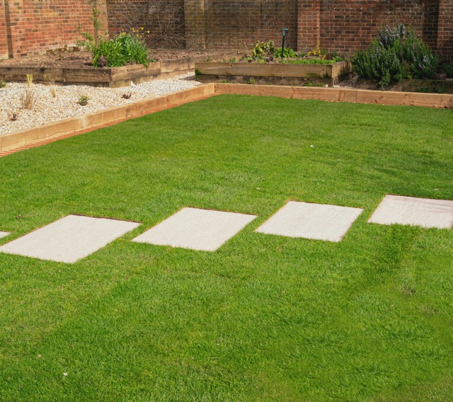Pas Japonais rectangles align&eacute;es sur pelouse dans un jardin