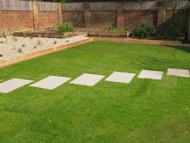 Pas Japonais rectangles align&eacute;es sur pelouse dans un jardin